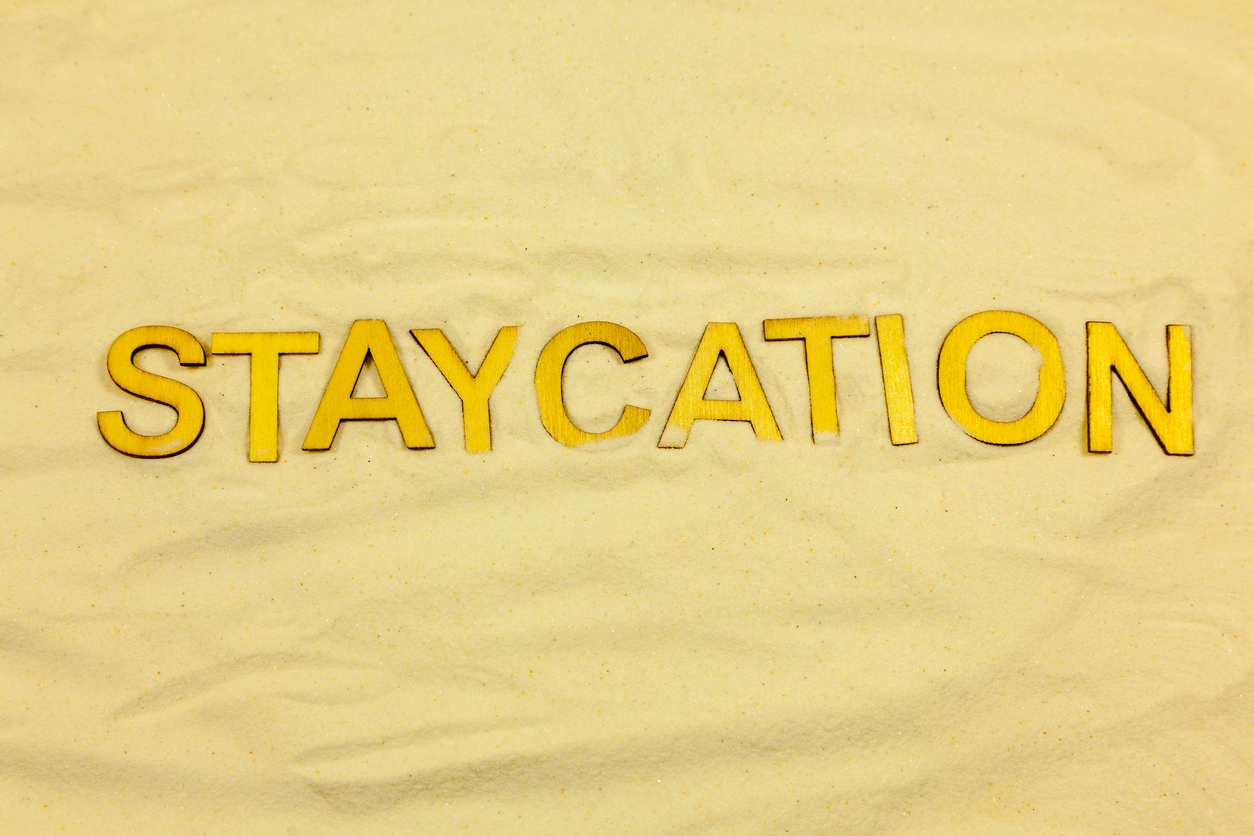 Sand background with the word 'Staycation'